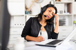 © JackF - Weary woman with microphone headset at work in office