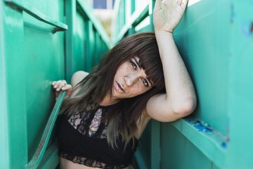 Poster - Young attractive Caucasian female with tattoos standing in the middle of wagons