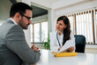© bnenin - Businessman on a medical consultation. Beautiful doctor holding paper document.