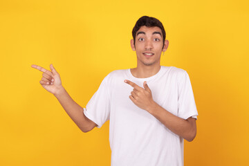 Wall Mural - young teenager man pointing isolated on color background with white t-shirt