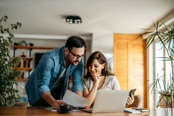 Couple doing finances at home, portrait.