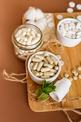 Wall Mural - Herbal nutrition supplements and vitamins on brown background. Healthy lifestyle and care about immunity.