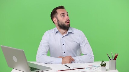 Wall Mural - Young business man in light shirt sit work at desk with pc laptop computer isolated on green background studio Achievement business career lifestyle concept looking camera around shocked surprised wow