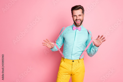 Portrait of his he nice attractive classy chic positive cheerful cheery funny brunet guy pulling suspenders posing fooling having fun corporate event isolated over pink pastel color background