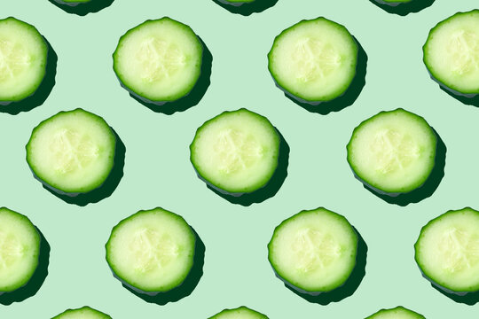 regular seamless pattern of cucumber slices on a pastel mint background.photo collage,hard light, sh