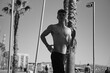 © Anton - Young attractive sporty man with naked torso jogging in the morning along beach. Black and white photo