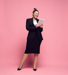 Wall Mural - Tablet scrolling. Young woman in office attire. Bodypositive female character, feminism, loving herself, beauty concept. Plus size businesswoman, elegant teacher, beautiful girl. Inclusion, diversity.