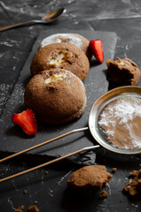 chocolate chip cookies on a table with strawberries and icing sugar