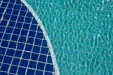 Background of rippled pattern of clean water in a blue swimming pool.