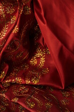 Red Fabric With A Gold Pattern. Drapery. 
Maroon Background
