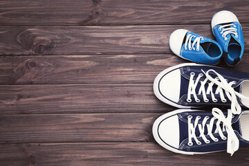 Father Day concept. Shoes of dad and son on brown wooden table