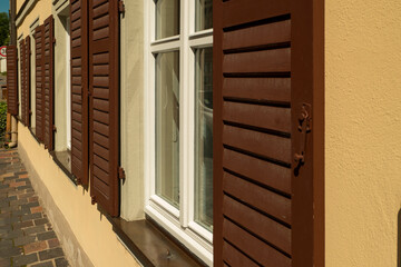 House facade with window with wooden shutter