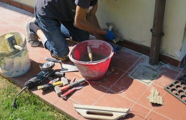 Sticker - Construction worker with a mask installing tiles on the wall