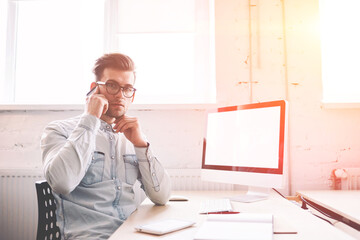 Poster - Confident male programmer talking with operator for checking account balance looking at camera while sitting indoors with computer with blank screen for your internet advertising on background