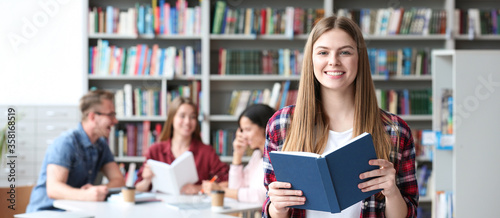 Fotomural Young student with book in library, space for text. Banner design
