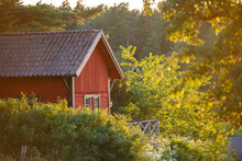 Red Summer Garden Cottage In Sweeden. Traditional Sweden Wooden Old House. Life On The One Of Sweeden Islands