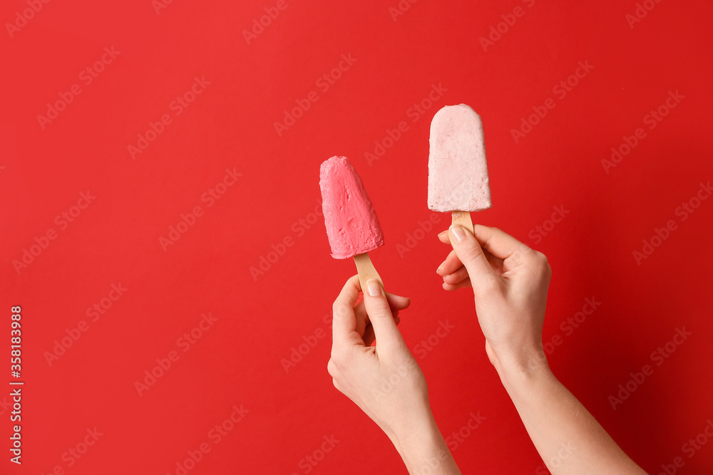Hands with tasty strawberry ice cream on color background