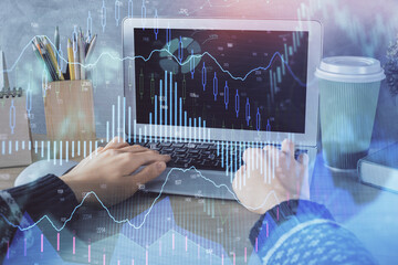 Double exposure of woman hands typing on computer and forex chart hologram drawing. Stock market invest concept.