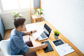 Fototapete - Working from home web designing graphical user interface UX UI, home office using computer laptop and pen sketching graphics tablet device creative planning innovative ideas, asian man quarantine
