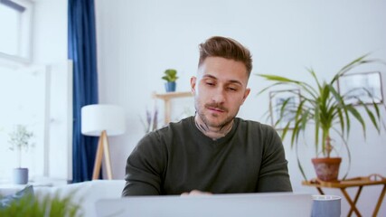 Wall Mural - Man with laptop working indoors at desk in home office, video call concept.