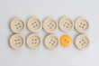 © Ahmad - A single out yellow button among white buttons,shot from top over a clear white surface