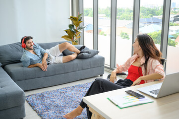 Happy and relax  lifestyle of young couple lover wearing casual dress together working on laptop notebook computer in living room at home.