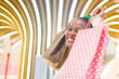 © TheVisualsYouNeed - lifestyle portrait of young happy and beautiful black afro American woman holding shopping bags buying at mall fashion store smiling cheerful enjoying sales in cool stylish outfit