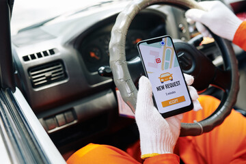 Wall Mural - Delivery man sitting in car getting new work request on his smart phone, horizontal close-up shot