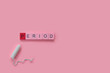 menstruation concept: word period spelled with pink letters on pink background with a tampon