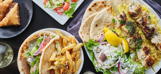 Wall Mural - greek meal with chicken souvlaki platter, gryos, french fries, salad and baklava