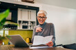 © bnenin - Happy senior woman receiving positive bank feedback in a letter, portrait.