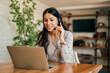 © bnenin - Portrait of a cute woman with headset and laptop at home office.
