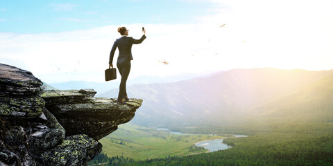 Businesswoman standing against landscape and making selfie