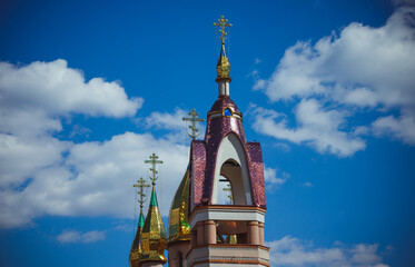 The top of the church with golden crosses on a background of blue sky on a sunny day.