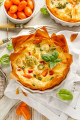 Wall Mural - Vegetable quiche, tart  made from filo pastry with the addition of broccoli, cauliflower and tomato top view