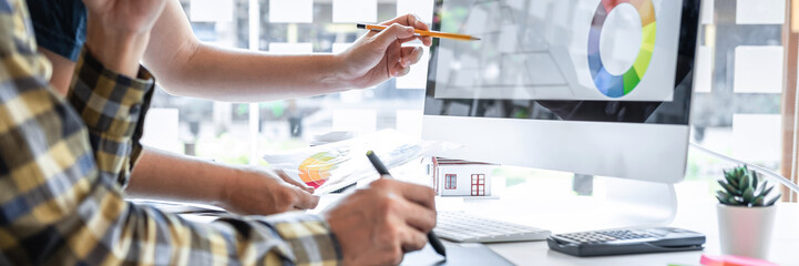 Young graphic designer working sketching on graphic tablet and color swatch