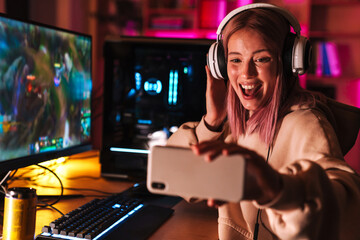 Poster - Image of girl taking selfie on cellphone while playing video game