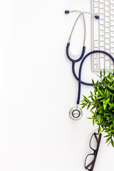 Stethoscope on doctor office desk. White background from above copy space