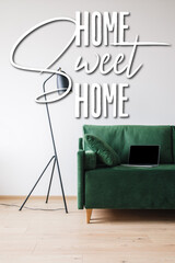 Wall Mural - laptop with blank screen on green sofa near floor lamp and home sweet home lettering