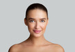 © Prostock-studio - Woman with perfect skin looking at camera at gray studio