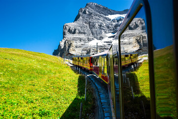 Canvas Print - Beautiful scenery with cogwheel red train of the famous Jungfrau Railway from Jungfraujoch ( Top of Europe) to Kleine Scheidegg, Bernese Oberland, Switzerland