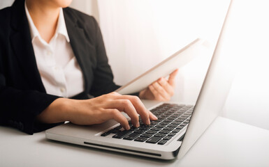 businesswoman hand using smart phone, tablet payments and holding credit card online shopping, omni channel, digital tablet docking keyboard computer at office in sun light with film grain effect