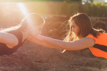 Happy successful sportswoman raising arms to the sky on golden back lighting sunset summer. Fitness athlete with arms up celebrating goals after sport exercising and working out outdoors. Copy space.