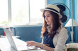 © themorningglory - Young smiling business asian entreprenure woman using smartphone with computer in home office