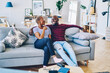 © BullRun - African american couple in love having conversation sitting at sofa at apartment,positive young marriage talking to each other recalling funny stories during free time in comfortable living room