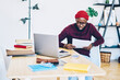 © BullRun - Pensive dark skinned male freelancer checking information from papers doing remote job at home interior, serious african american hipster guy in spectacles reading report sitting at desktop.