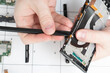 © yta - Installation of original spare parts on a mobile phone. A specialist repairs a smartphone in a service center