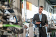 © Westend61 - Young businessman with tablet and workpiece at a machine in a factory