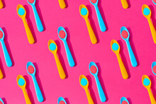Seamless Pattern Of Yellow And Blue Plastic Teaspoons With Blue And Red Liquid