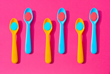 Pattern Of Yellow And Blue Plastic Teaspoons With Blue And Red Liquid